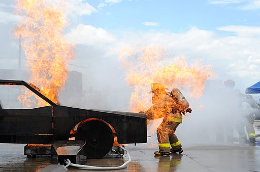 firefighter opening the hood of a simulated car on fire