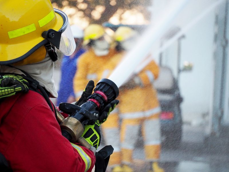 Firefighter using a fire hose during training