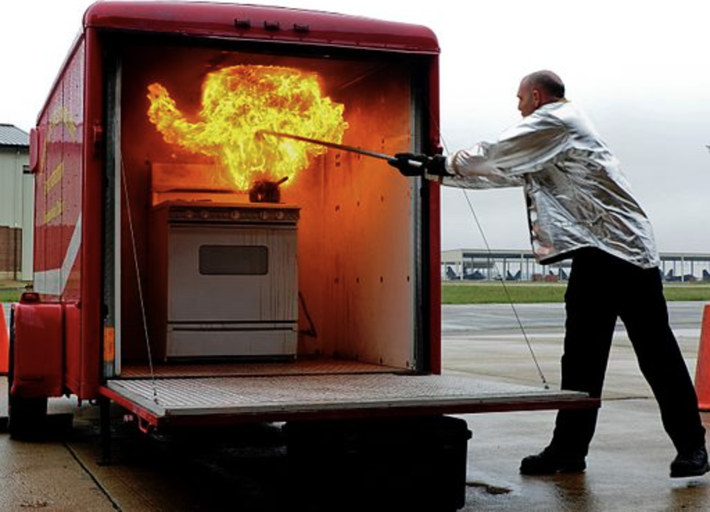 firefighter demonstrates extinguishing a grease fire