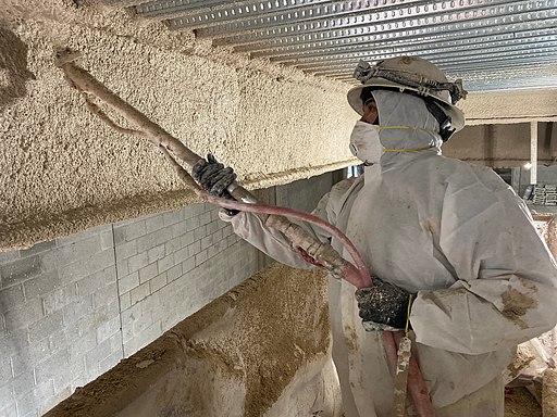 firefighter spraying cement fireproofing